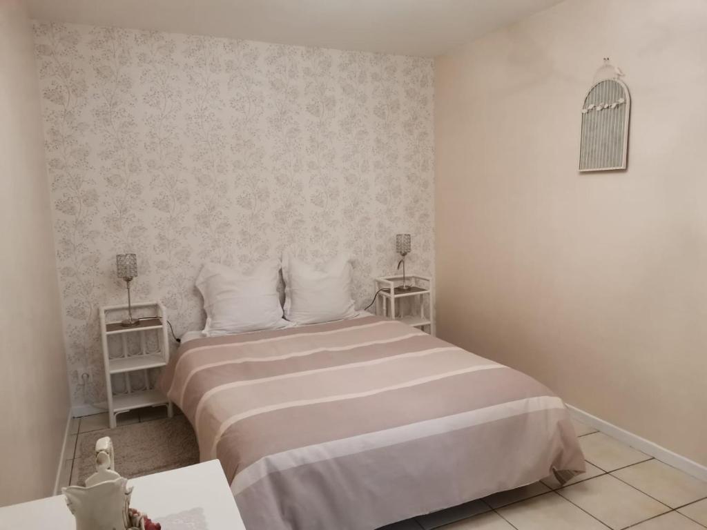 une chambre avec un grand lit blanc avec deux tables dans l'établissement Gite Regal, à Suaux