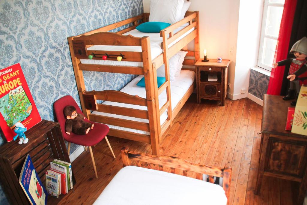 a bedroom with two bunk beds and a desk at Gîte Le Féodal 3 Etoiles in Tiffauges