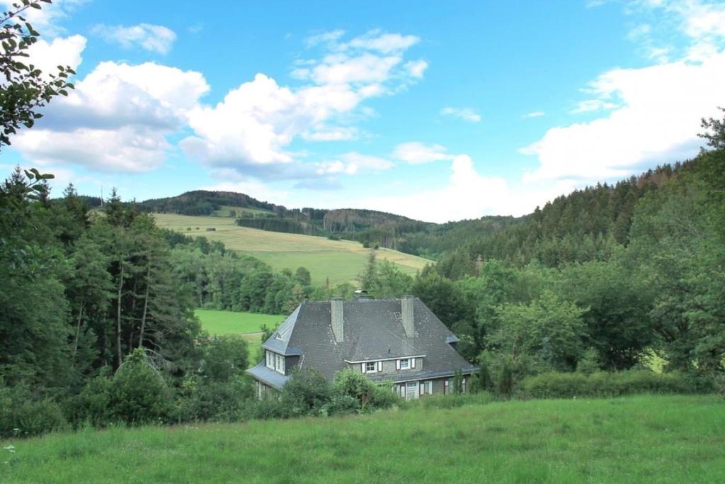ein Haus mitten auf einem grünen Feld in der Unterkunft Ferienhaus Stefano in Bad Berleburg
