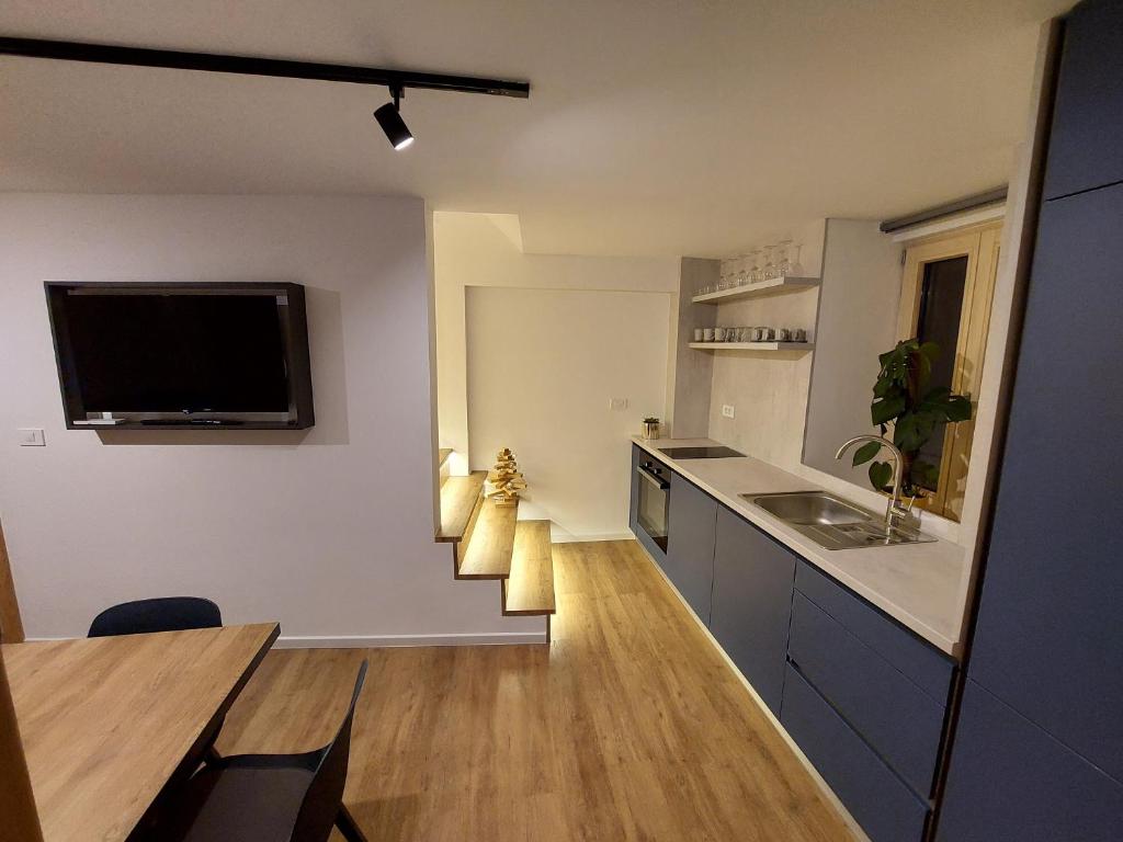 Casa Gray 2 في كوبر: مطبخ مع طاولة وتلفزيون على الحائط