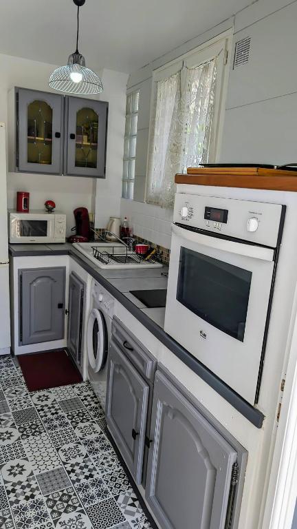 a kitchen with a sink and a stove top oven at Maison proche de Disneyland, de Paris et des JO in Pomponne