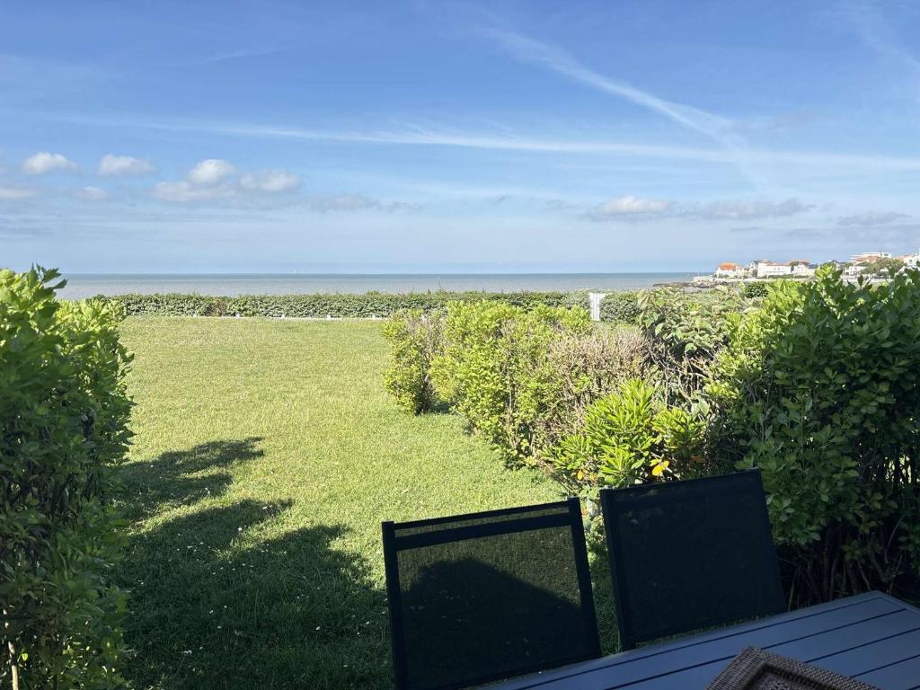 une vue sur une pelouse avec vue sur l'océan dans l'établissement Studio en bord de mer à Royan, parking, TV, tout équipé - FR-1-494-67, à Royan