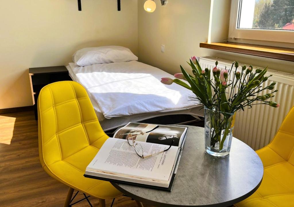 a room with a table and chairs and a bed at Willa Ogrodnika in Błażowa