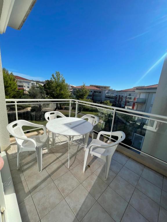 un patio avec une table et des chaises sur un balcon dans l'établissement Deux pièces climatisé plage à pied et garage, à Antibes