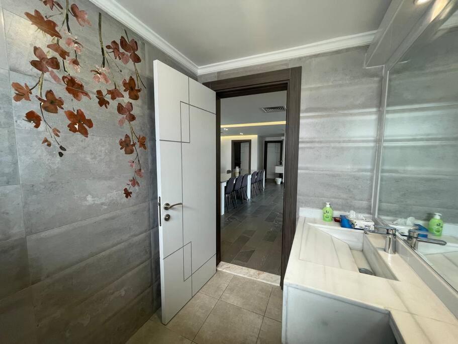 uma casa de banho com um lavatório e um espelho em X Beach House em Al Khiran