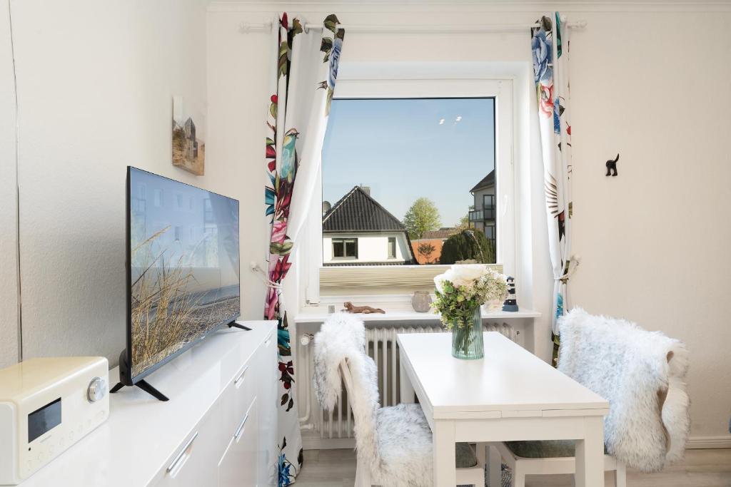 a living room with a tv and a table at Steffi s Vogelnest in Scharbeutz