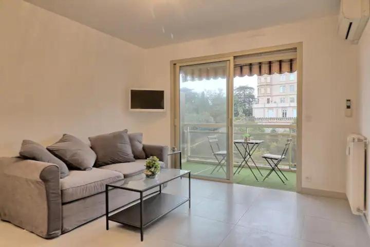 un salon avec un canapé et une table dans l'établissement Appartement proche des Plages et du Palais, à Cannes