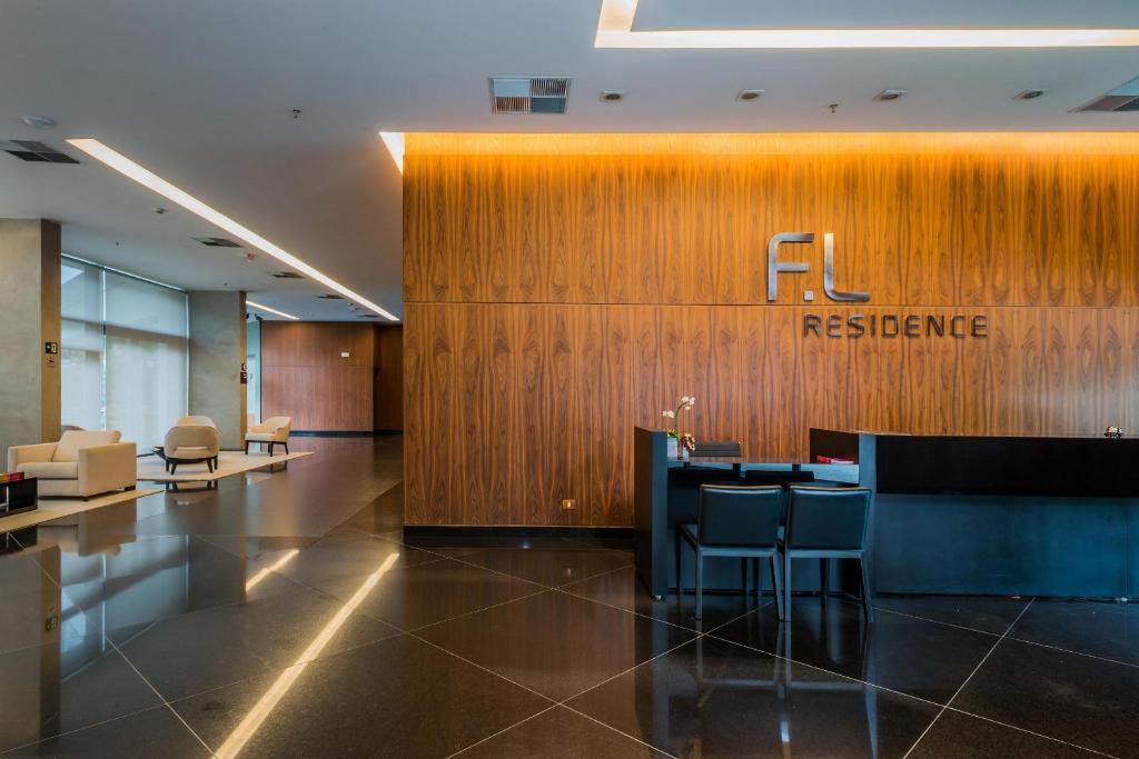 un hall d'entrée avec un panneau de référence sur un mur en bois dans l'établissement FL Residence, à São Paulo