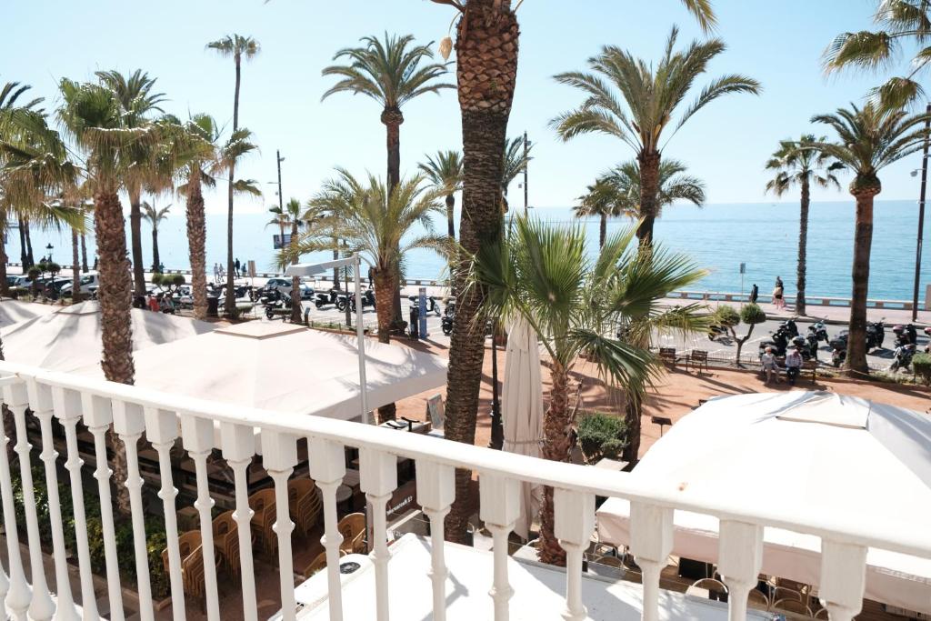 a balcony of a resort with palm trees and the ocean at Exclusive Beachfront Haven in Costa Brava in Lloret de Mar