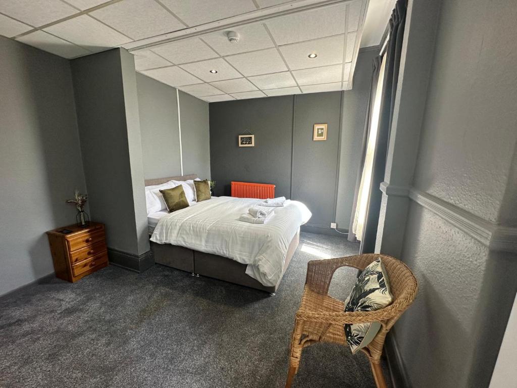 - une chambre avec un lit, un miroir et une chaise dans l'établissement Manchester Stay Hotel - Free Parking, à Manchester