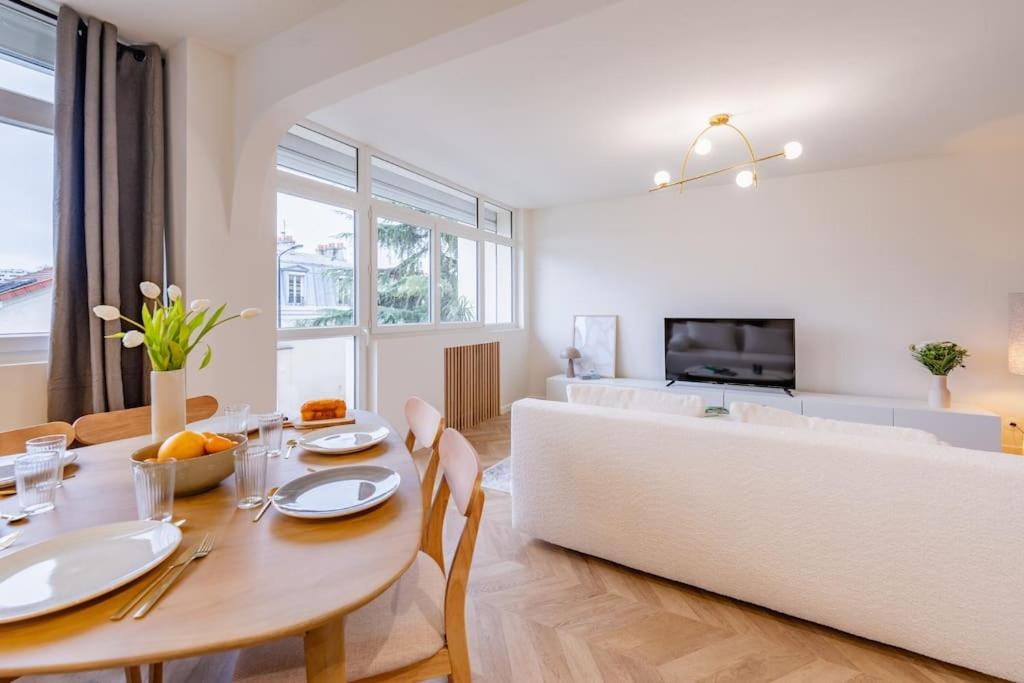 un salon avec une table et un canapé dans l'établissement L’écrin de douceur pour 4/6 personnes + parking privé, à Courbevoie