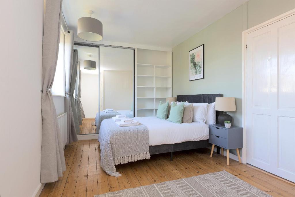 a bedroom with a large bed and a mirror at The Morden Hall Collection in Morden