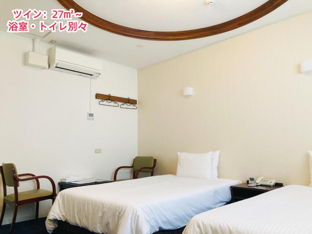 a hotel room with two beds and two chairs at Hotel Precia Naha Tsujimachi - Vacation STAY 17058v in Naha