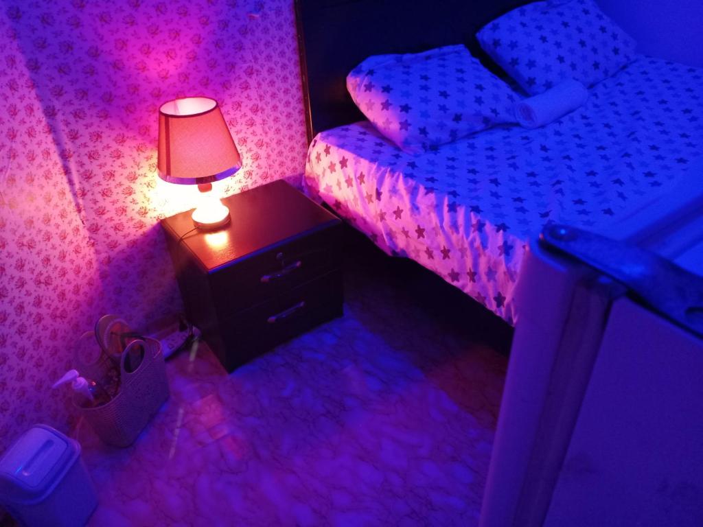 ein Schlafzimmer mit einem Bett und einer Lampe auf einem Nachttisch in der Unterkunft Khalidiya in Abu Dhabi