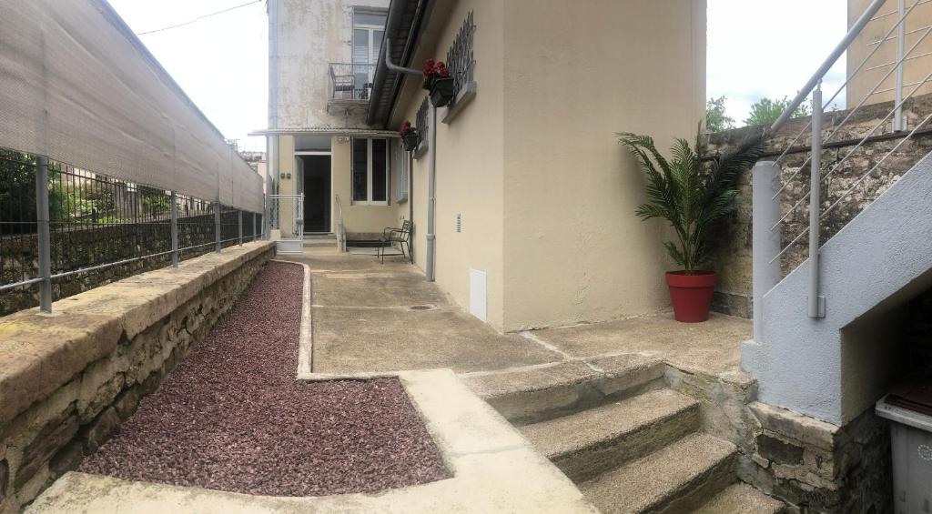 einen Flur eines Gebäudes mit Treppen und einer Pflanze in der Unterkunft Meublés déco Fab - Tapas in Luxeuil-les-Bains