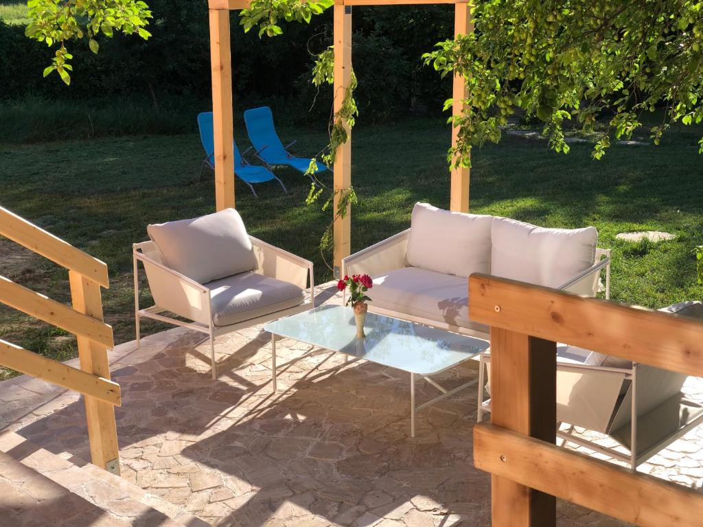 a patio with a couch and two chairs and a table at Pink Garden Events Advance Notice Required in Giarmata