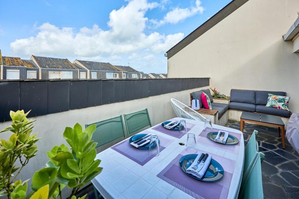 d'une terrasse avec une table et des assiettes de nourriture. dans l'établissement Prince - À 500m de la plage, à Courseulles-sur-Mer