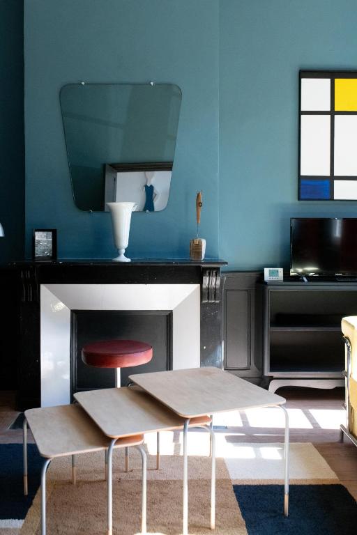 une pièce avec une table et deux chaises devant une cheminée dans l'établissement Le 5 - maison de style centre ville Normandie, à Eu