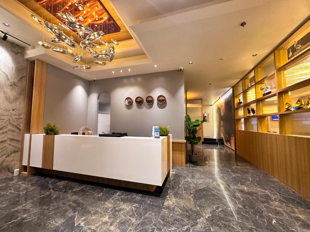 a lobby with a reception desk and a chandelier at Hotel Park Royal in Dwarka