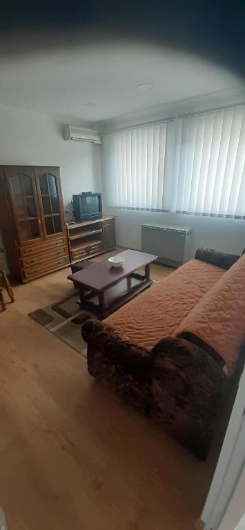 Apartman Car في Prijepolje: غرفة بسرير وطاولة قهوة