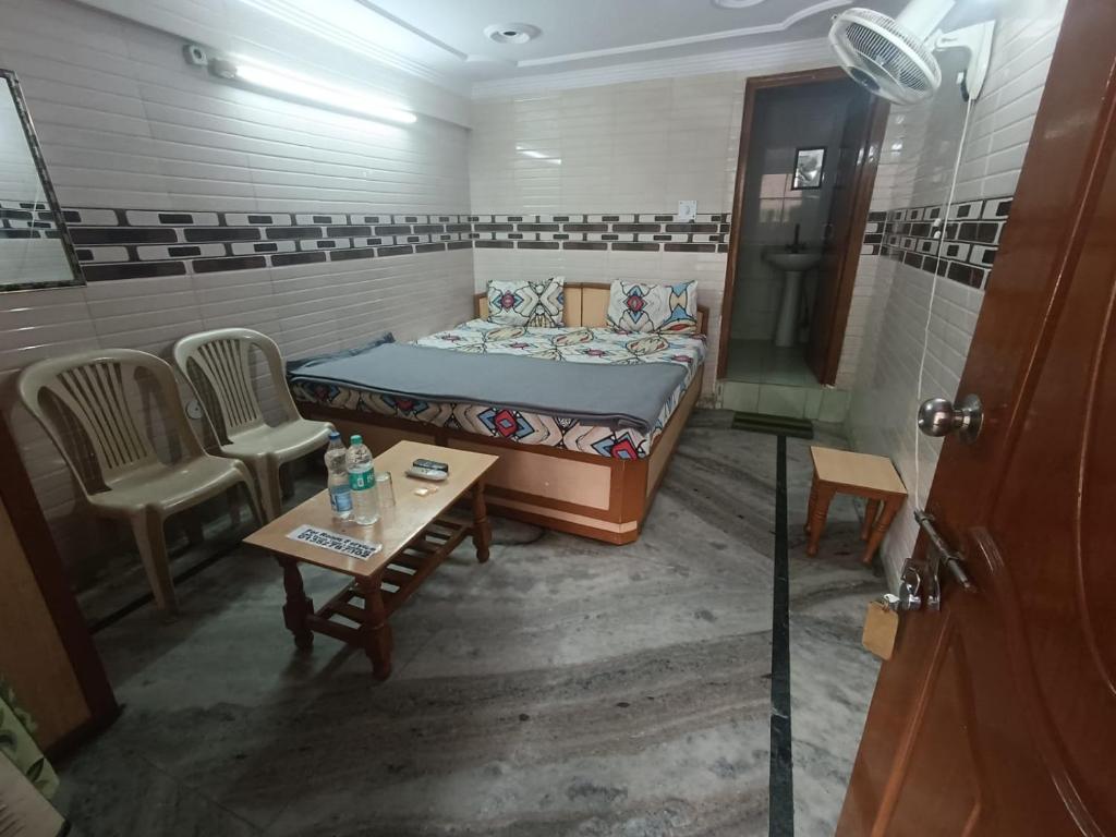 a small room with a bed and chairs and a table at Hotel Rajpal Guest House in Dehradun