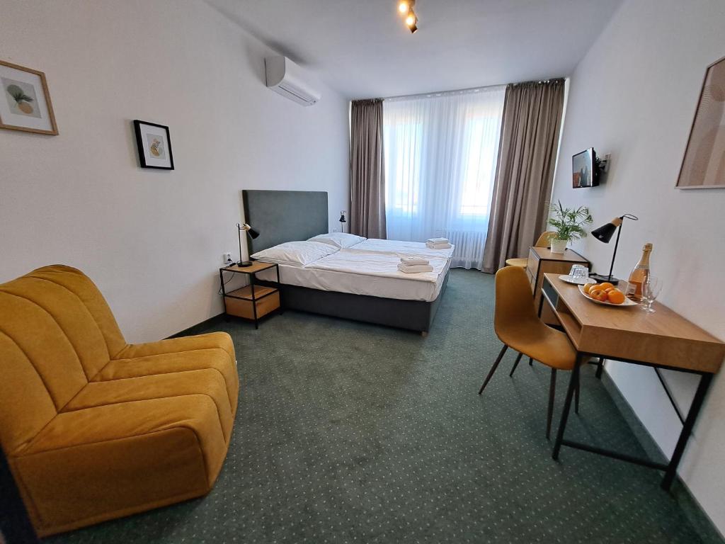 プラハにあるホテル レギエのベッドと椅子付きのホテルルーム