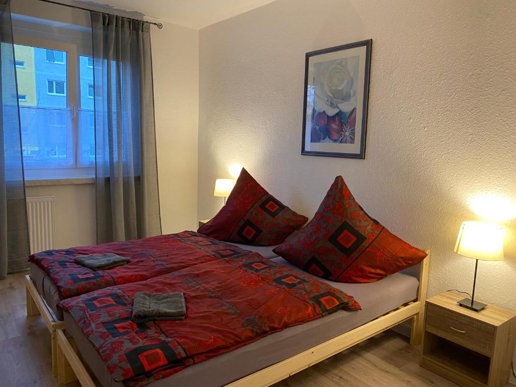 um quarto com uma cama com almofadas vermelhas e uma janela em 80 m² neues vier Zimmer Apartment 