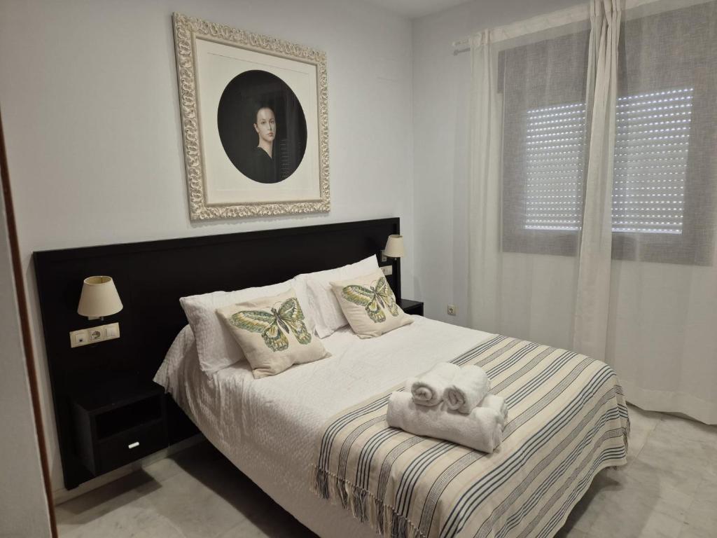 una camera da letto con un letto e asciugamani di LuxSevilla Moderno 1 Room Piscina Parking a Bormujos