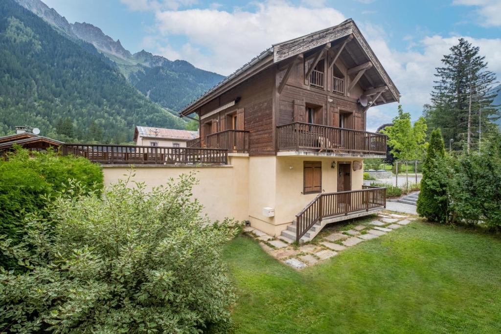 ein Haus mit einem Balkon und einem Rasenhof in der Unterkunft Chalet Ski & in out - Flegere - Free Parking in Chamonix-Mont-Blanc