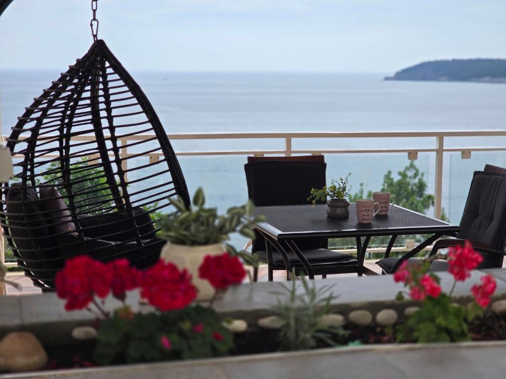 uma mesa e cadeiras numa varanda com vista para o oceano em Indy's Beach Apartments em Dubrovnik