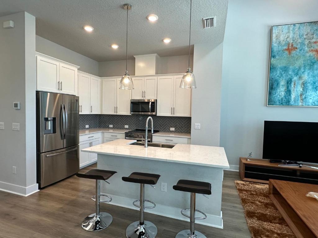 a kitchen with a counter and a sink and a refrigerator at Luxurious Three-story Townhouse In Payne Park Village in Sarasota