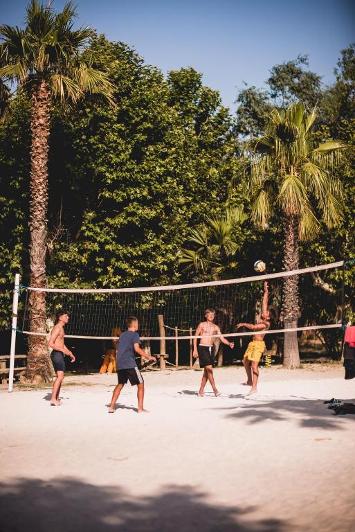 eine Gruppe Männer, die Volleyball spielen in der Unterkunft Les Prairies de la Mer in Grimaud
