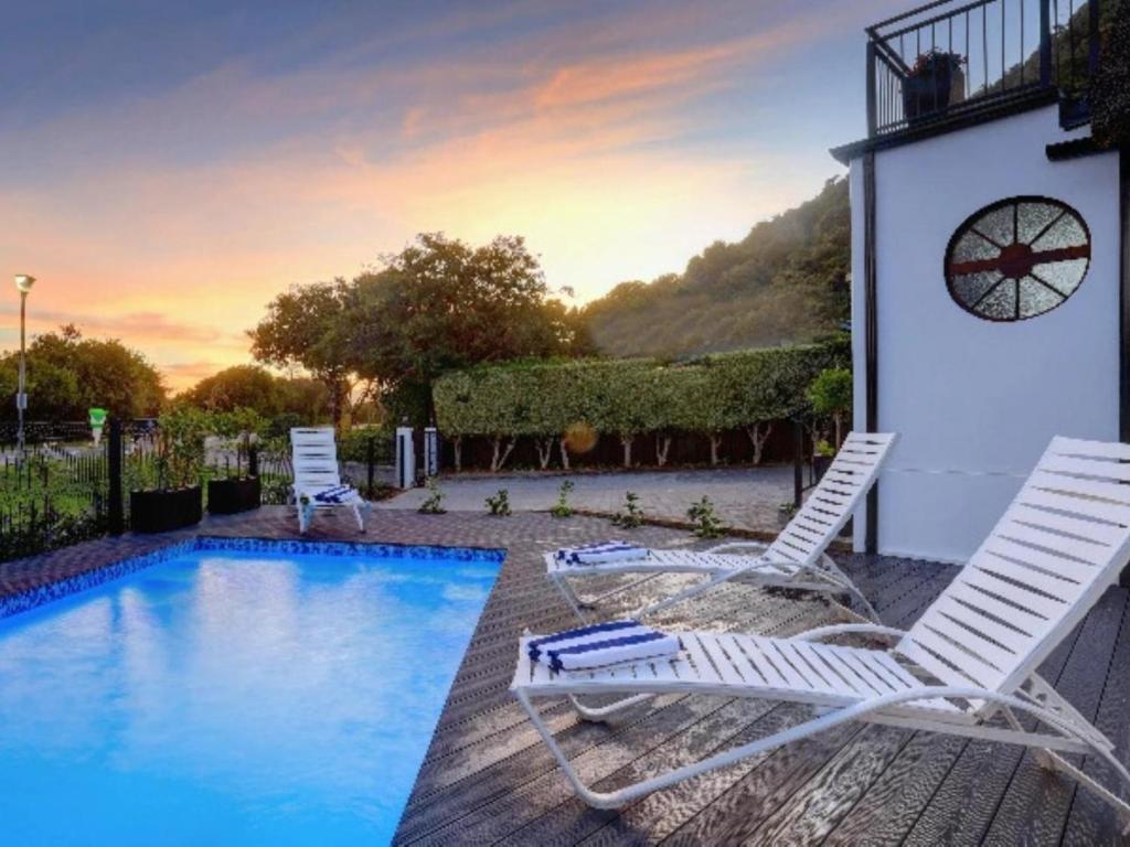 two chairs sitting next to a swimming pool at Cloverleigh Guest House in Wilderness