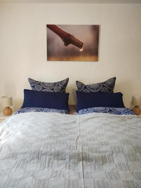 1 dormitorio con 1 cama con almohadas azules en Urlaub beim Winzer, en Klingenmünster