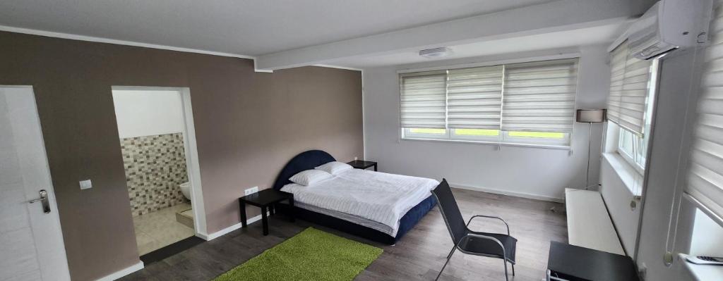 a bedroom with a bed and a bathroom with a window at Urban villa in Sarajevo