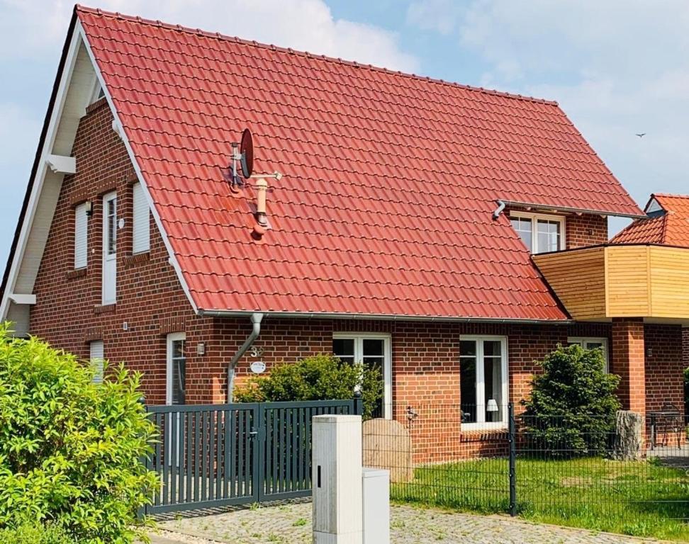 a house with a red roof with a dog on it at Haus Schwalbennest in Dassow