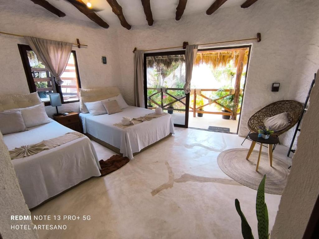 a bedroom with two beds in a room with windows at Arte Sano Hotel - Adults only in Holbox Island