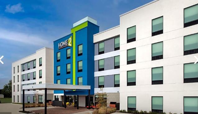 Un gran edificio blanco con un cartel de Nike. en Home2 Suites by Hilton Stevens Point, en Stevens Point