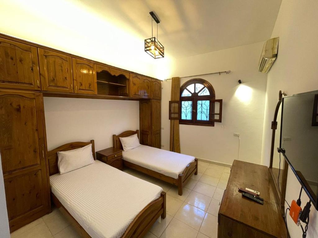 1 dormitorio con 2 camas, mesa y ventana en Red oasis, en Dahab