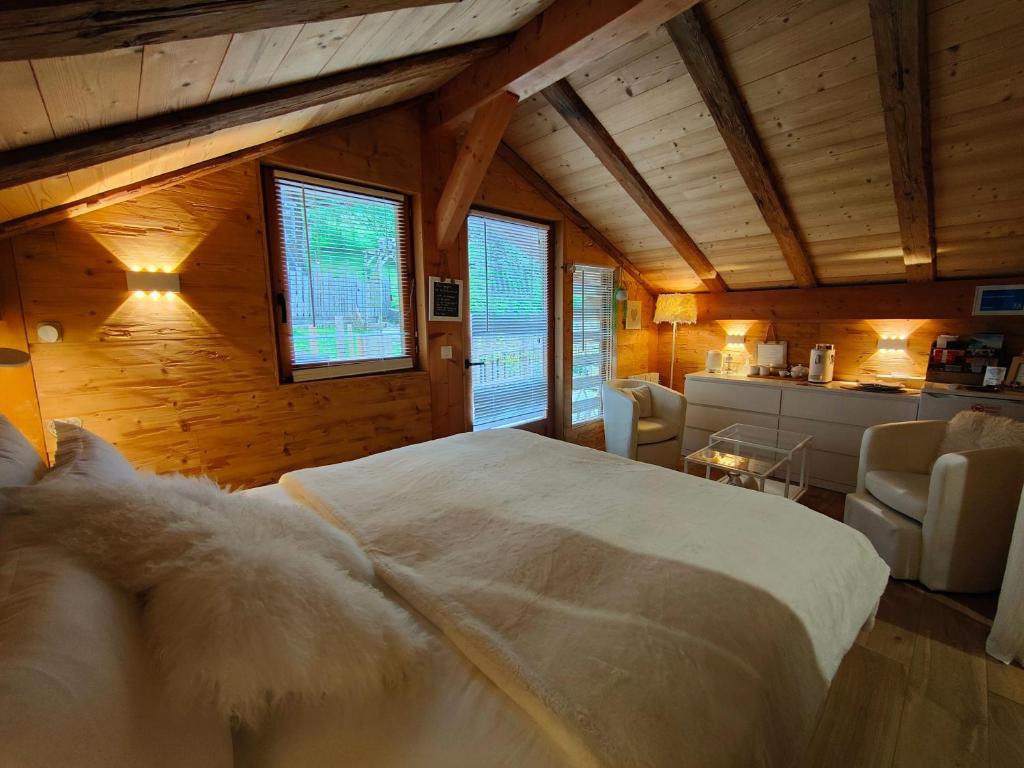 - une chambre avec un grand lit blanc dans une pièce dotée de murs en bois dans l'établissement Chambre Boille à Lait, à Entremont