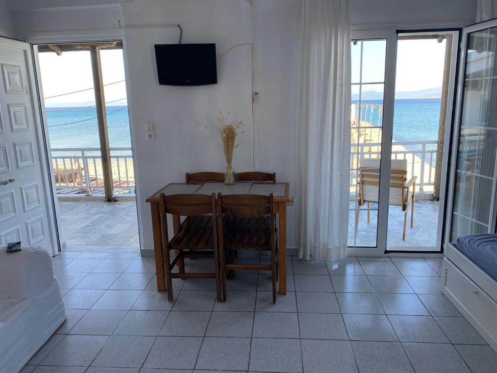 a dining room with a table and a view of the ocean at Anemomylos apartment sea view in Pefkohori