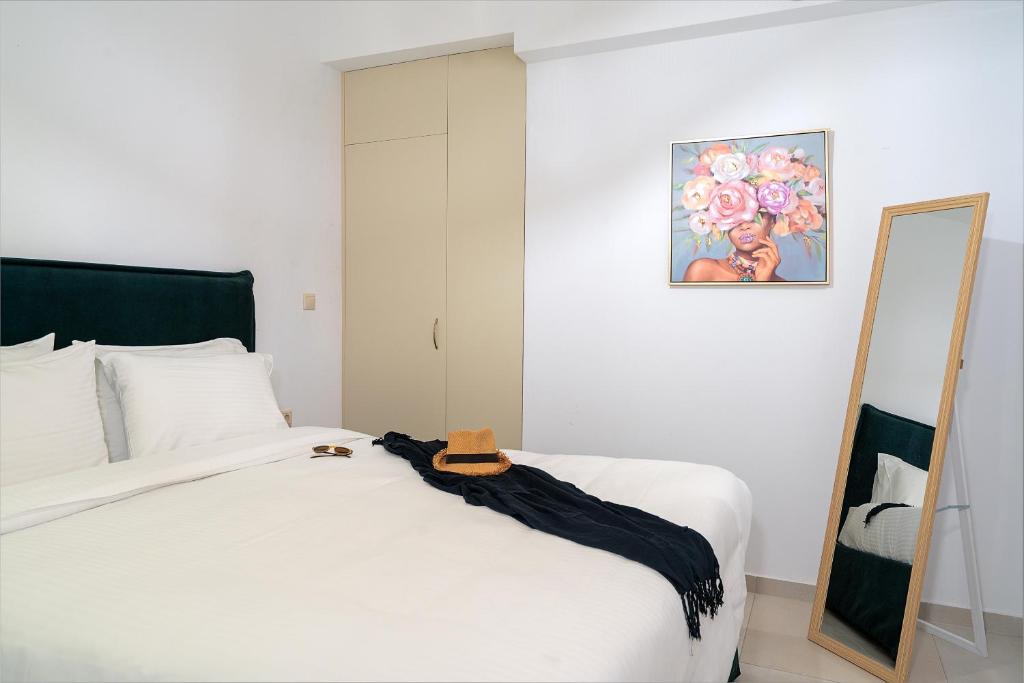Schlafzimmer mit einem weißen Bett und einem Spiegel in der Unterkunft Sueño Seaside Residence in Agia Pelagia