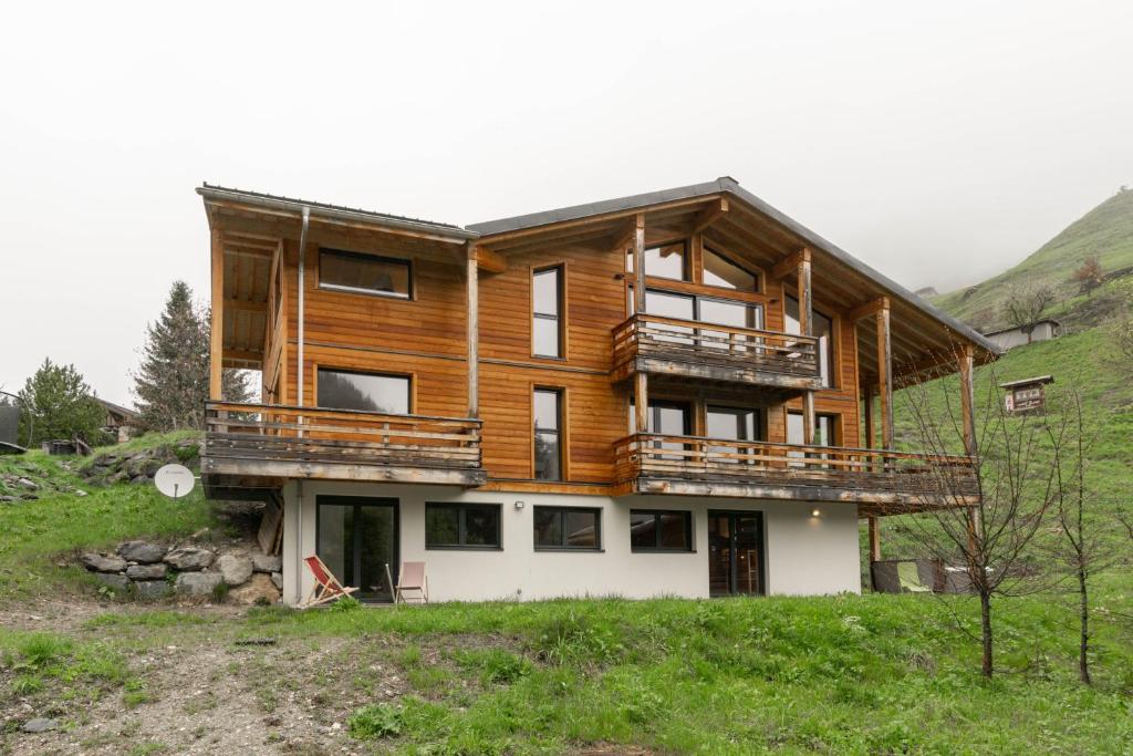 a large wooden house on top of a hill at Chalet Olbios in Peisey-Nancroix