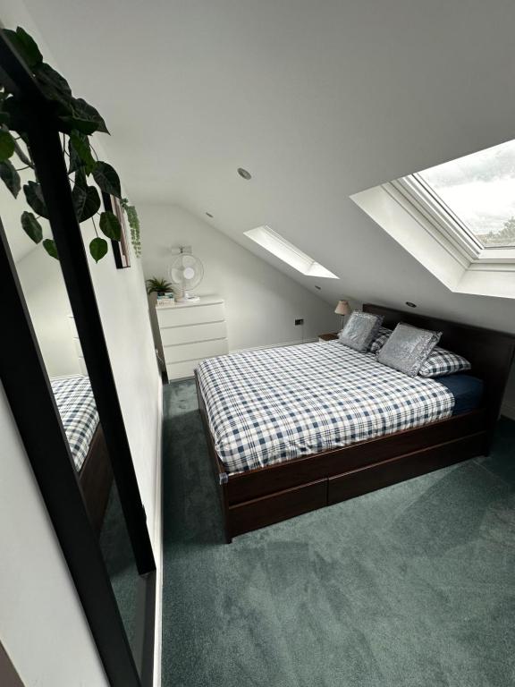 1 dormitorio en el ático con 1 cama y tragaluz en Private self-contained flat with shared entrance en Londres
