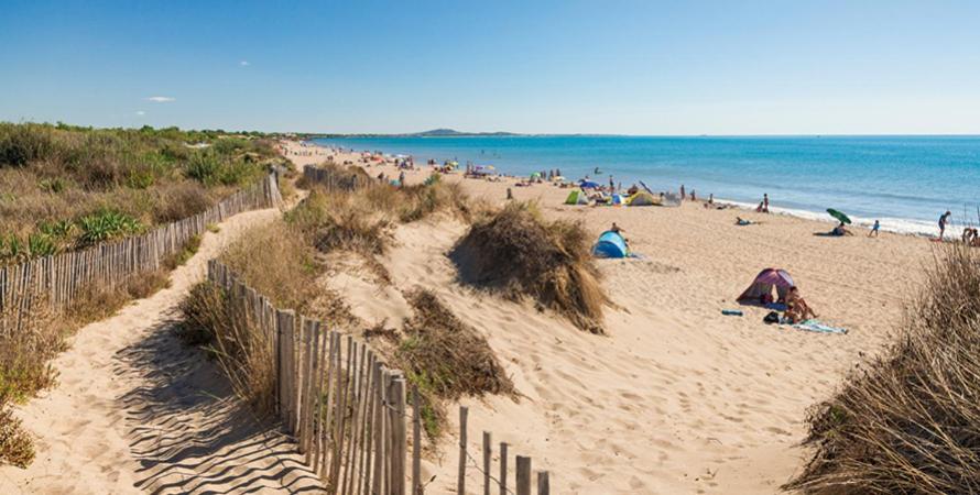 un groupe de personnes sur une plage près de l'océan dans l'établissement T3-HELTYMIE-terrasse-4 pers-idéal famille-parking gratuit-5 min des plages, à Portiragnes