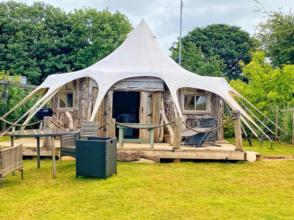 a tent with a table and chairs in a field at Bella in Abergele