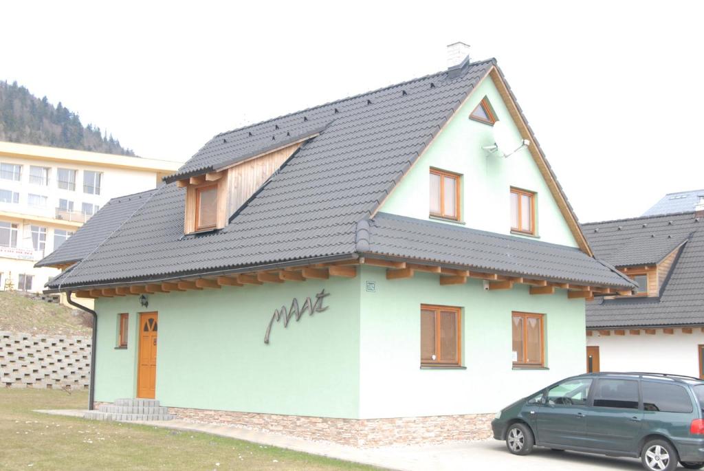 a small white house with a black roof at Apartment Maat in Donovaly