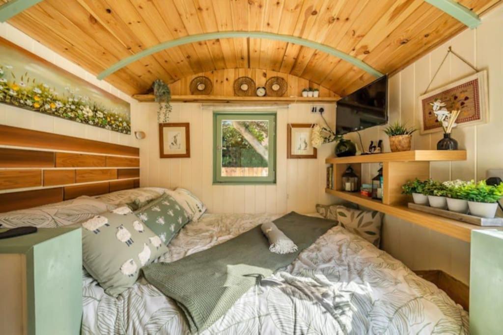 een slaapkamer in een tiny house met een bed bij Spinney Retreats - 2 x Unique Shepherds Huts Dog Friendly in Northampton