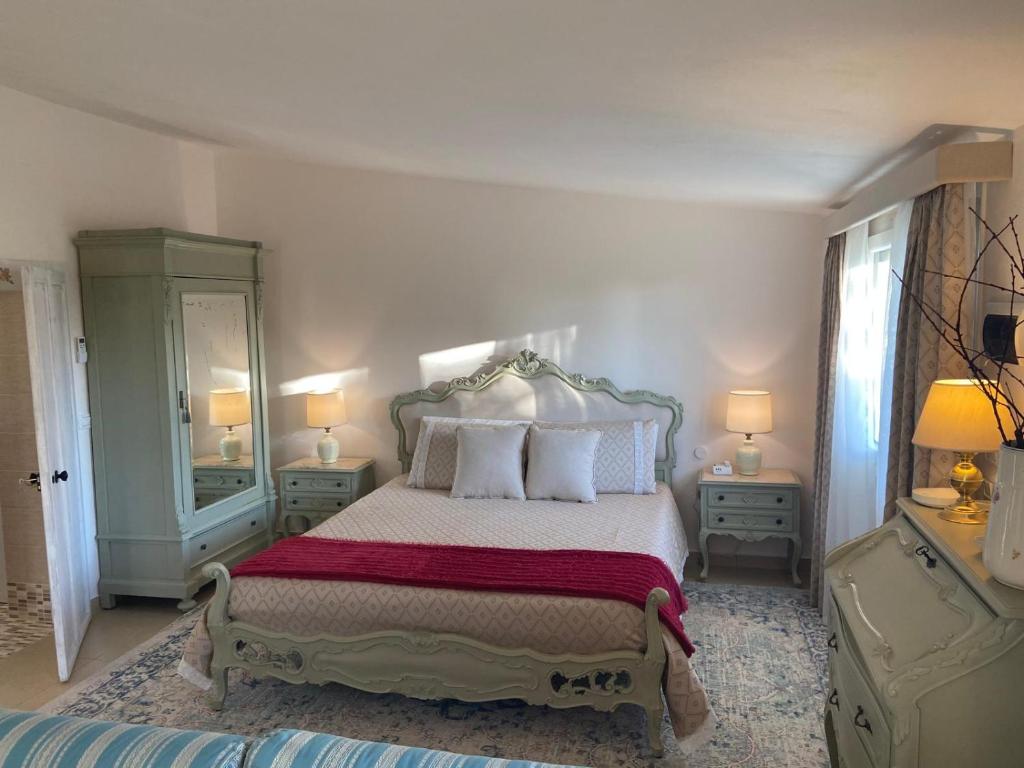 1 dormitorio con 1 cama, 2 lámparas y espejo en Tenuta Le Mandorlaie, Agriturismo in Scansano, en Scansano