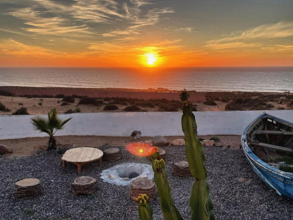einen Sonnenuntergang über dem Meer mit einer Feuerstelle in der Unterkunft Riad Ocean Beach Douira in Agadir